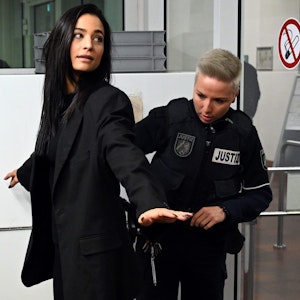 Amira Pocher im Amtsgericht in Köln bei der Sicherheitskontrolle. Eine Polizistin tastet sie ab.