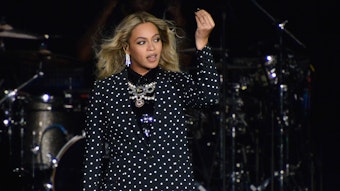 Beyoncé hebt bei einem Auftritt ihren Arm.