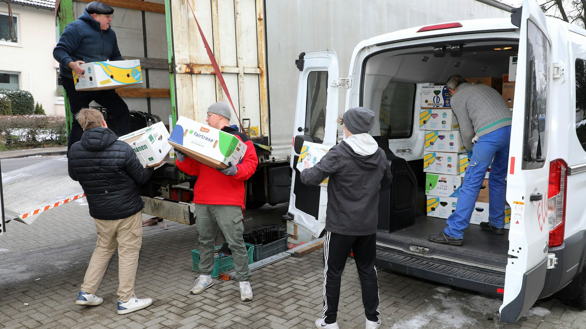 Helfer beladen einen Lastzug mit Hilfsgütern, die in Kartons verpackt sind.