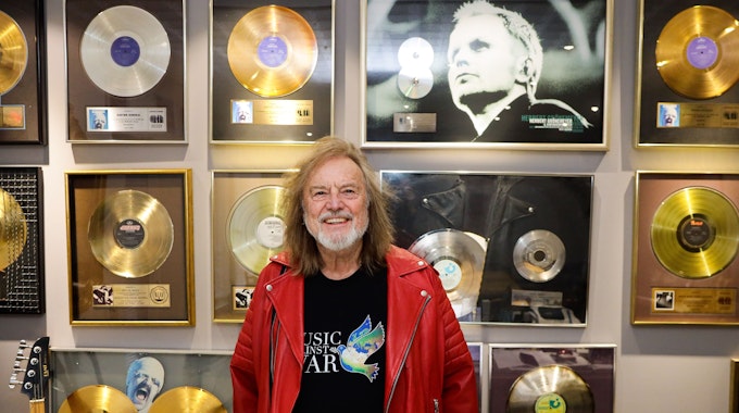 Dieter Dierks steht in seinem Büro vor einer Wand mit goldenen Schallplatten.