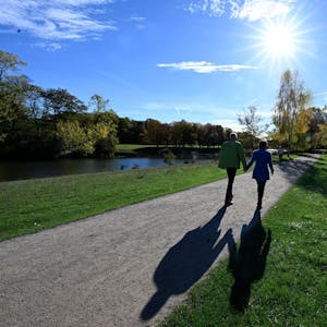 Nordrhein-Westfalen, Köln: Spaziergänger nutzen den Sonnenschein und die warmen Temperaturen für einen Spaziergang durch den Kölner Grüngürtel am Decksteiner Weiher.&nbsp;