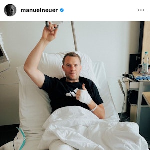 Manuel Neuer gibt einen Daumen nach oben aus dem Krankenhausbett.
