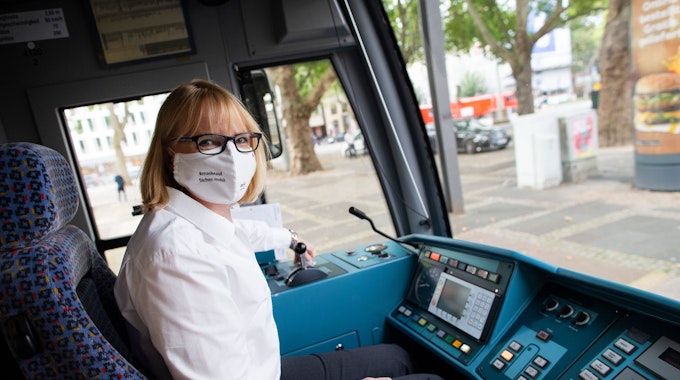 Stefanie Haaks, Chefin der Kölner Verkehrs-Betriebe sitzt mit Mund-Nase-Schutz am Steuer einer Kölner Stadtbahn.