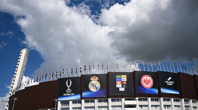 UEFA-Supercup vor dem Spiel Real Madrid - Eintracht Frankfurt im Olympiastadion in Helsinki. Die Vereinslogos von Real Madrid (l) und Eintracht Frankfurt prangen an der Fassade des Olympiastadions.