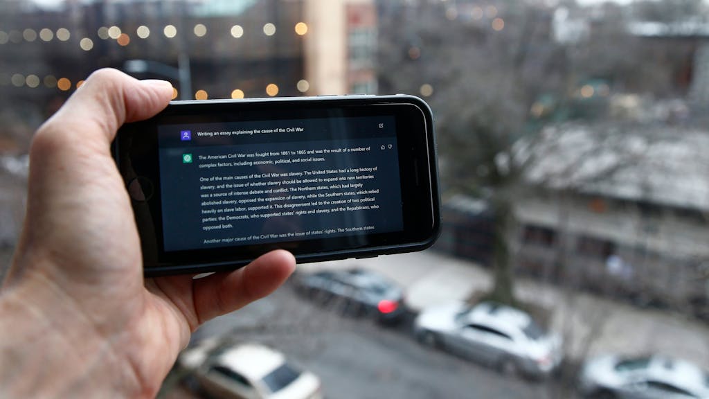 Eine Person zeigt einen Text der Künstlichen Intelligenz ChatGPT auf einem Smartphone.