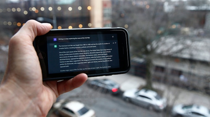 Eine Person zeigt einen Text der Künstlichen Intelligenz ChatGPT auf einem Smartphone.
