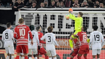 Jonas Omlin, Torwart von Borussia Mönchengladbach (in gelb), lässt den Ball fallen, Dion Beljo (verdeckt) trifft zum vermeintlichen 1:0 für den FC Augsburg. Das Tor am 25. Januar 2023 zählt aber aufgrund einer Abseitsstellung nicht.