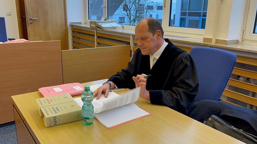 Oberstaatsanwalt Ulf Willuhn blättert in seinen Akten in der Strafsache gegen einen Kölner Hooligan.