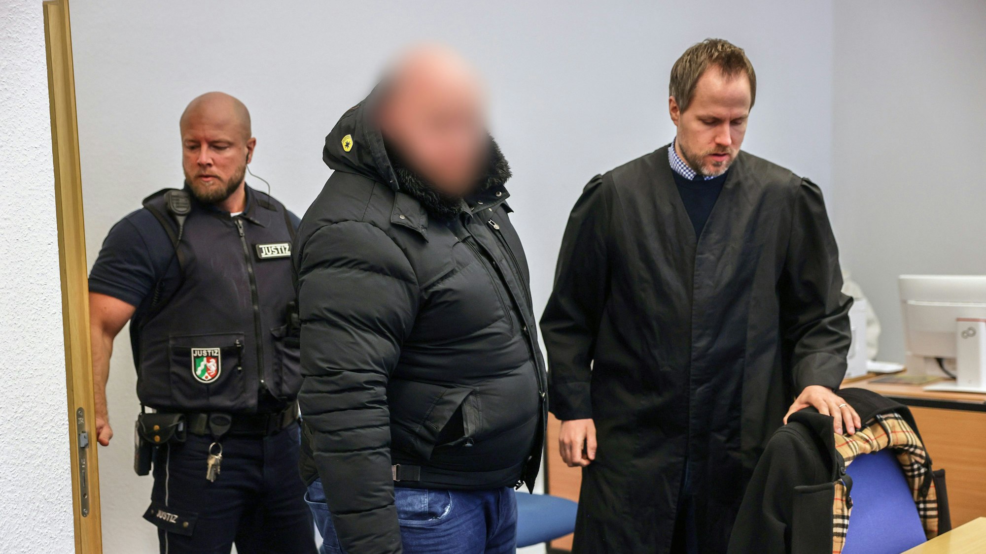 Der Angeklagte (M.) steht im Gerichtssaal neben seinem Verteidiger Ingmar Rosentreter (r.).
