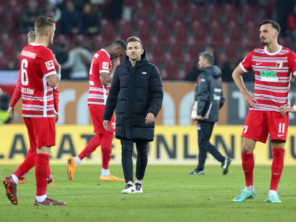 Augsburgs Trainer Enrico Maaßen (M) und seine Spieler nach dem Spiel.
