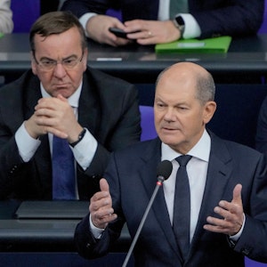 Bundeskanzler Olaf Scholz begründet im Bundestag gestikulierend seine Entscheidung, Leopard-Panzer an die Ukraine zu liefern. Im Hintergrund links Verteidigungsminister Boris Pistorius.