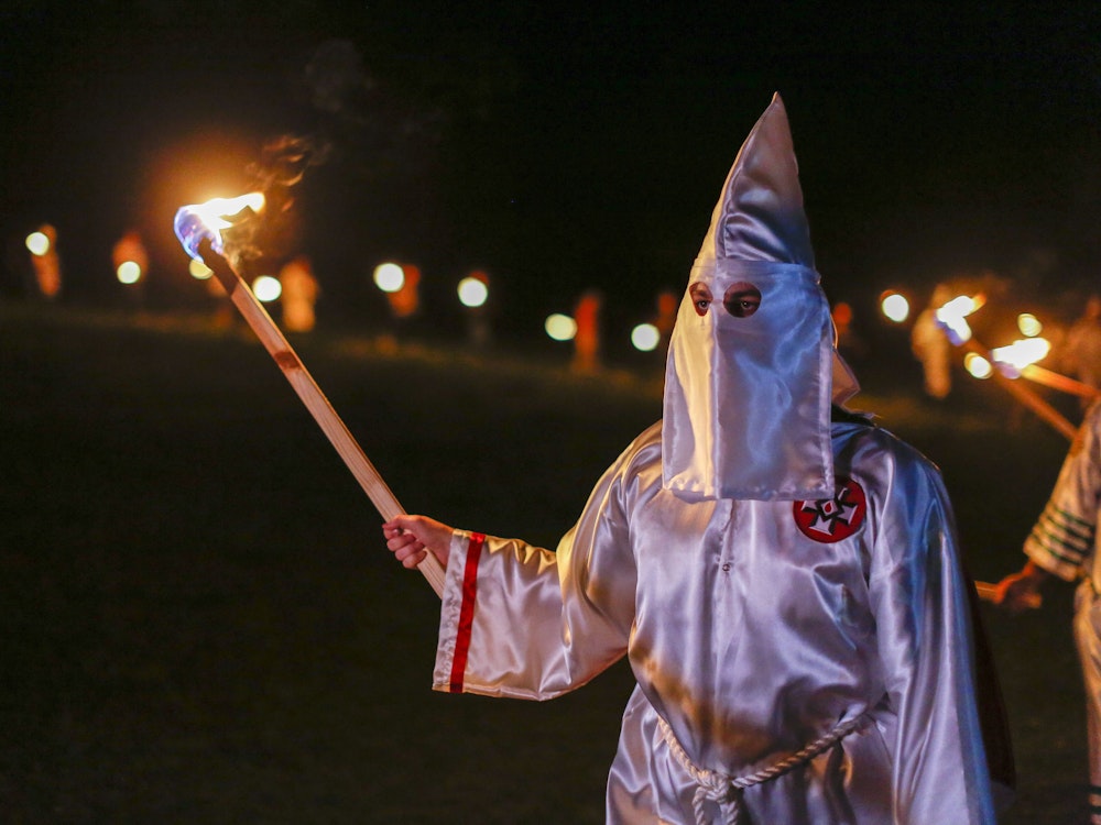 Ein Mann mit „Ku-Klux-Klan“-Gewand und Fackel.