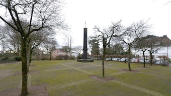 Der Deutsche Platz mit Bäumen und einem Denkmal.