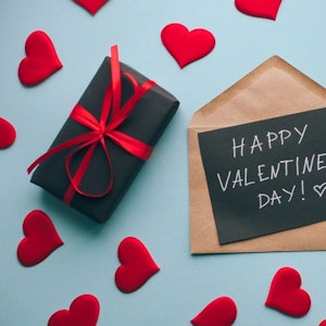 Valentinstagskarte mit handgeschriebenem Text und Gift Box, von roten Herzen umgeben