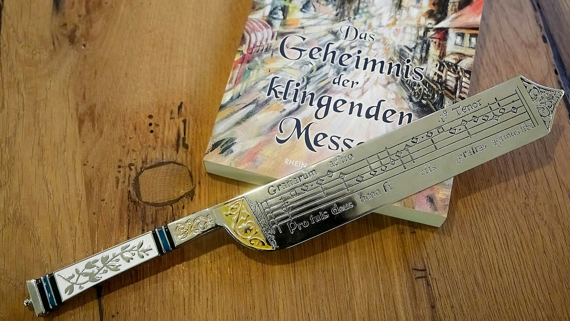 Ein kunstvoll gearbeitet Messer mit eingravierten Musik-Noten liegt auf einem Buch.