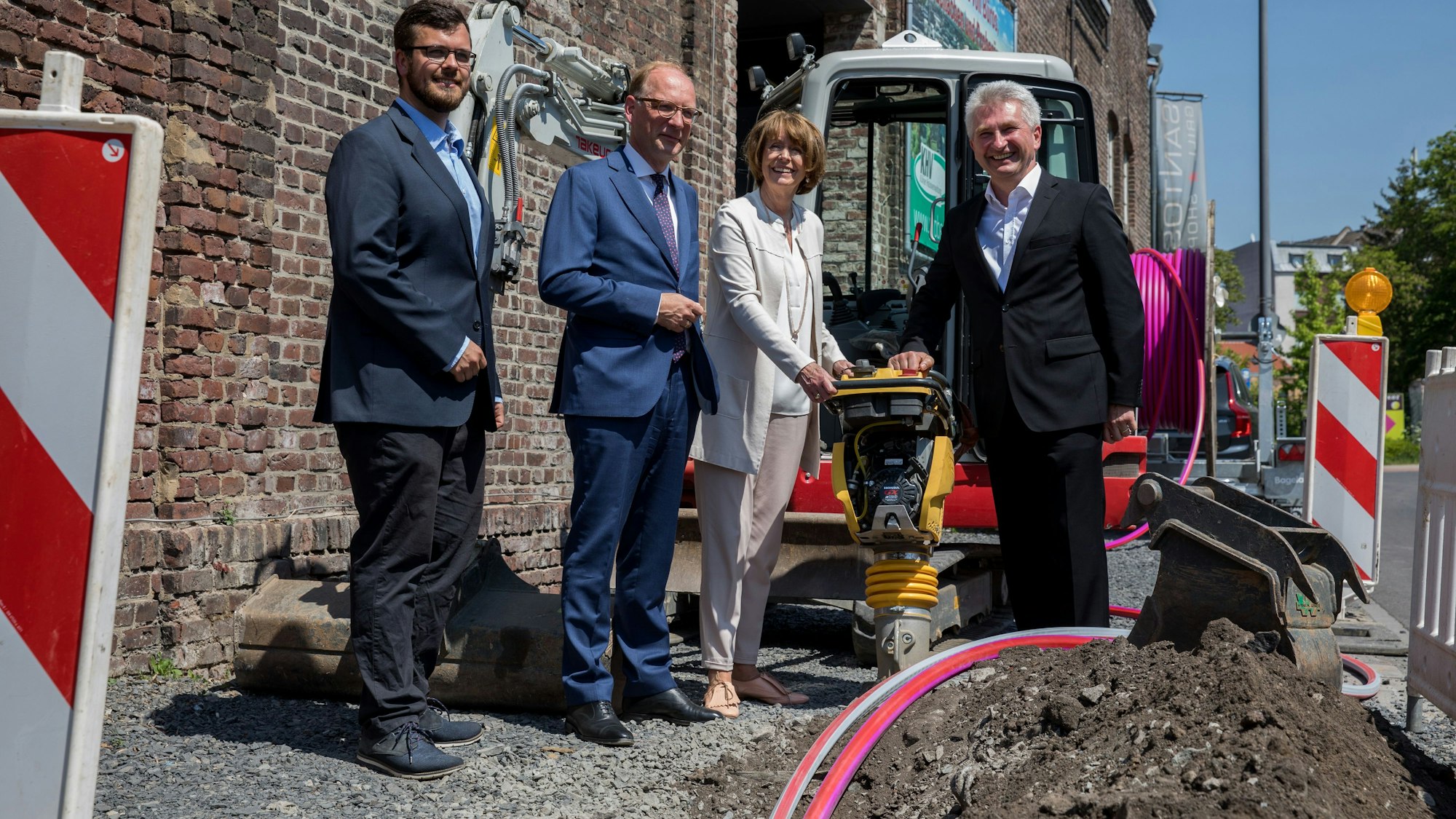 An einer Glasfaser-Baustelle in Köln stehen Fördermittel-Experte Michael Witte, Netcologne-Chef Timo von Lepel, Oberbürgermeisterin Henriette Reker und dem damaligen Wirtschaftsminister Andreas Pinkwart (FDP).