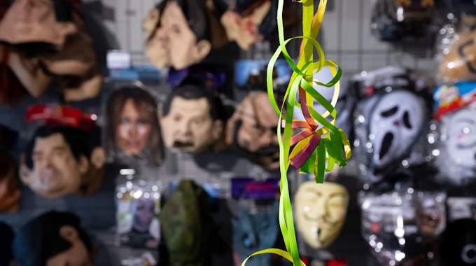 Verschiedene Masken hängen in einer Köstum-Filiale in einem Regal vor einer Luftschlange aus Papier. (Symbolbild)