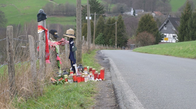 Schals, Mützen, Kerzen und Blumen liegen am Straßenrand in Odenthal.