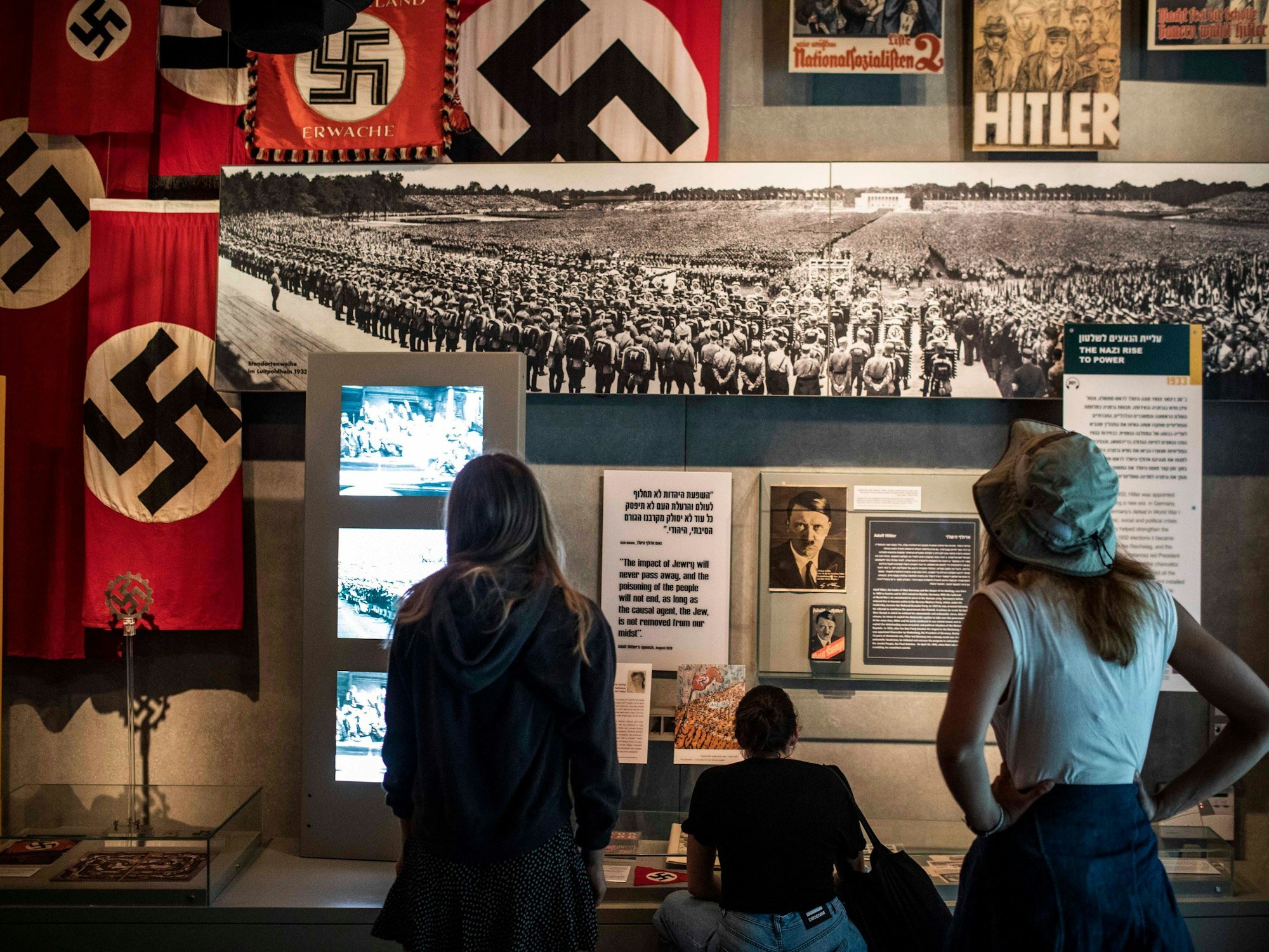 Drei Frauen schauen sich eine Ausstellung am Holocaust-Gedenktag im Museum Yad Vashem an.