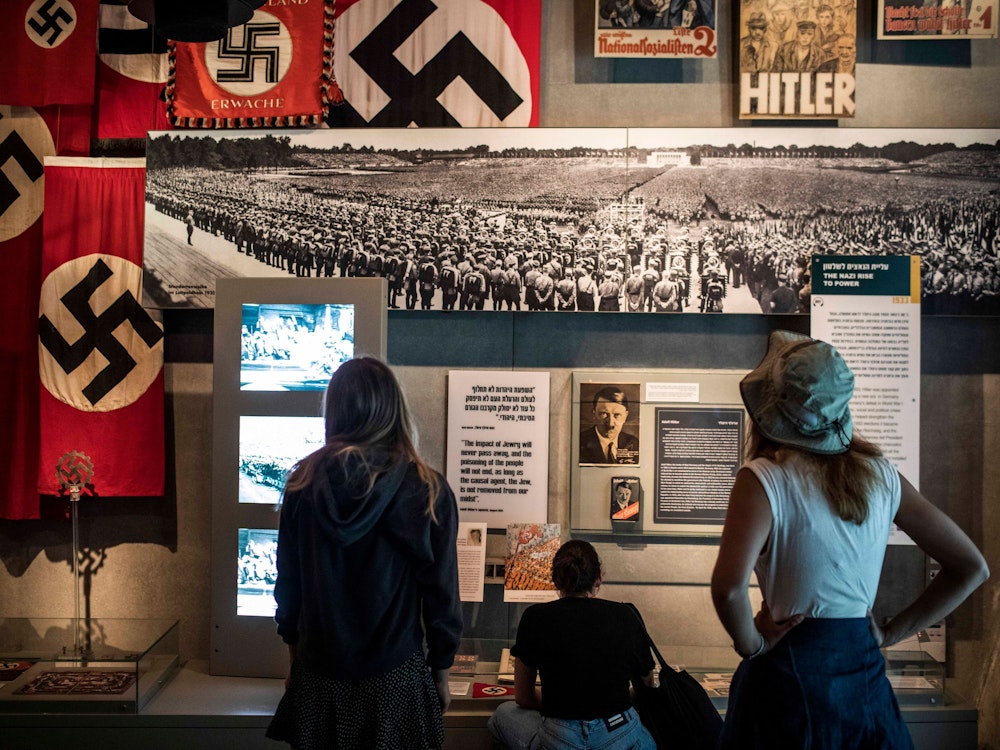 Drei Frauen schauen sich eine Ausstellung am Holocaust-Gedenktag im Museum Yad Vashem an.