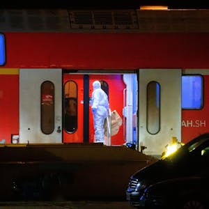 Ein Ermittler im weißen Schutzanzug arbeitet in dem Regionalzug, der auf ein Abstellgleis in Neumünster gefahren worden war.