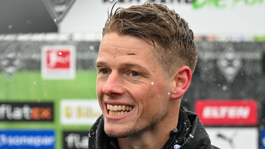 Jonas Omlin, Torhüter von Borussia Mönchengladbach, hier am 20. Januar 2023 in einer Medienrunde am Trainingsplatz im Borussia-Park. Sein Gesicht ist in Nahaufnahme zu sehen, er lächelt breit und freut sich.
