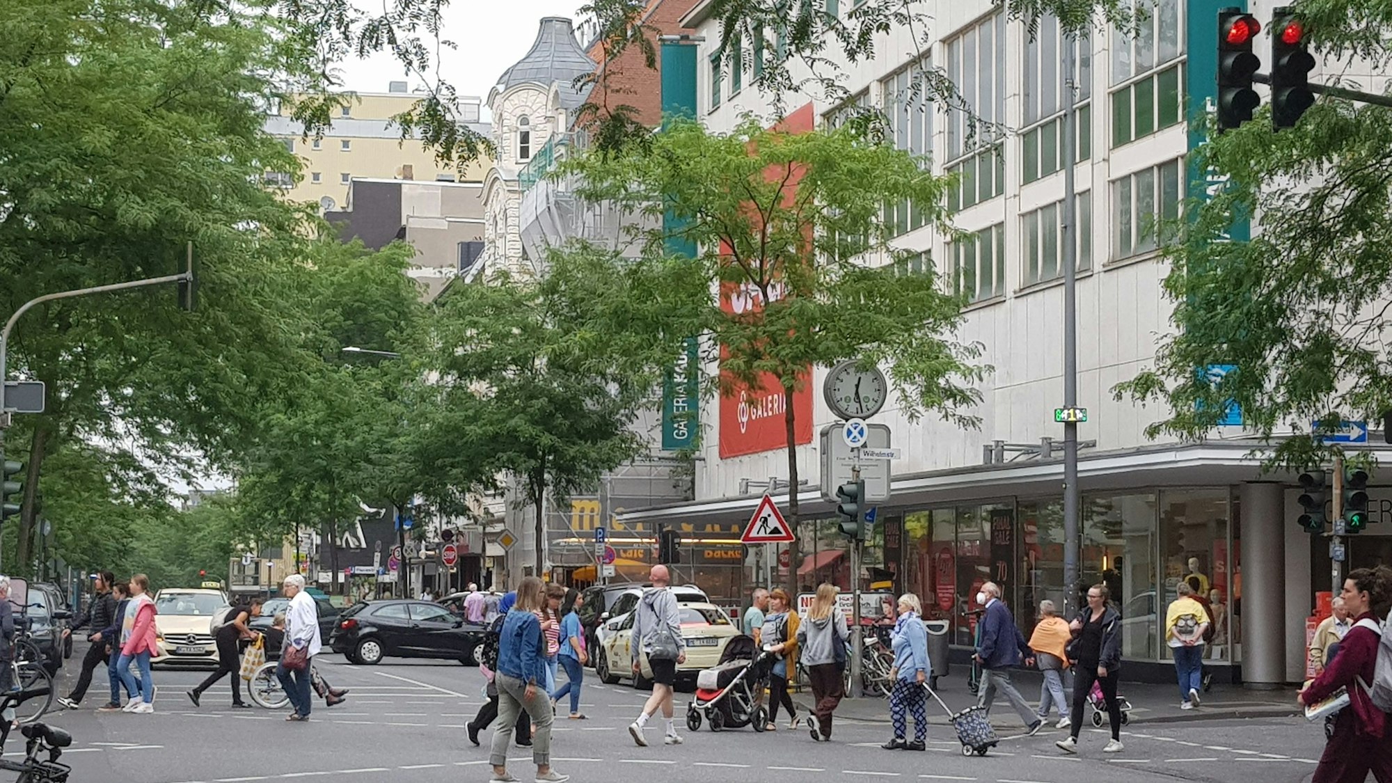 Viele Fußgänger gehen an der Kaufhof-Filiale über die Neusser Straße in Nippes.