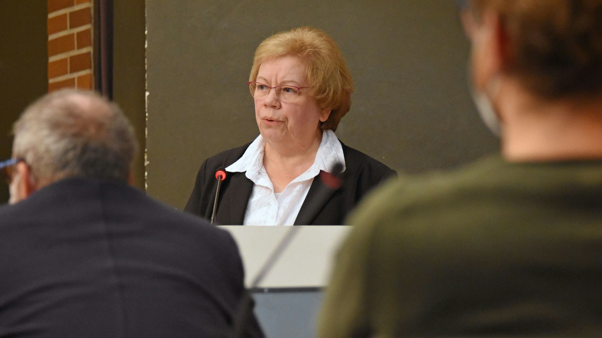 Helga Lagotzky, eine ältere Frau mit kurzen blonden Haaren und roter Brille, spricht im Burscheider Rat.
