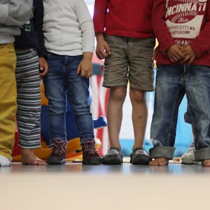 Es sind Füße und Beine von Kindern zu sehen, die nebeneinander stehen.