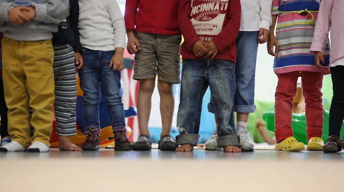 Es sind die Beine mehrerer Kinder zu sehen, die nebeneinander stehen.