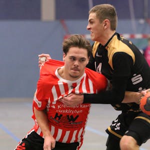 Zwei Spieler der HSG Euskirchen und des TVE Bad Münstereifel kämpfen um einen Ball.
