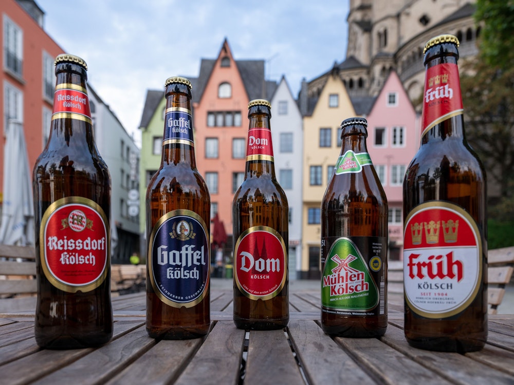 Flaschen verschiedener Kölsch-Marken stehen auf einem Tisch in der Altstadt.