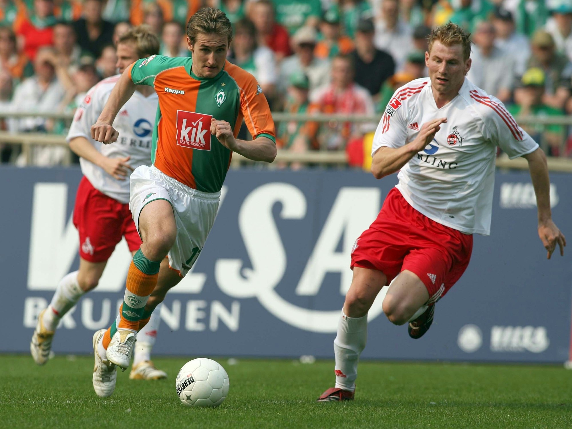 Bremens Miroslav Klose (l.) läuft mit dem Ball am Fuß und wird verfolgt von Kölns Lukas Sinkiewicz.