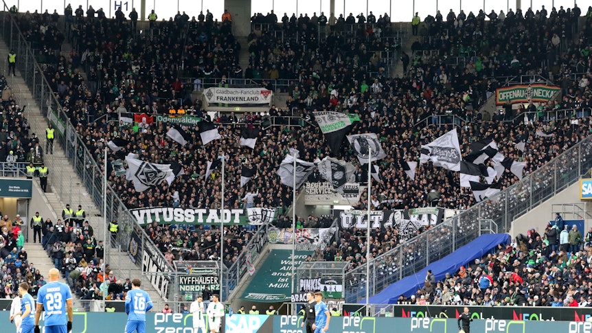 Der Fan-Block von Borussia Mönchengladbach während des Bundesliga-Spiels (28. Januar 2023) bei der TSG Hoffenheim in der Sinsheimer Arena. Zu sehen sind Banner der Gladbach-Ultras und Fahnen.
