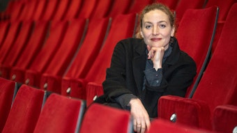 Die Schauspielerin Ines Marie Westernströer sitzt in einem Theatersaal.