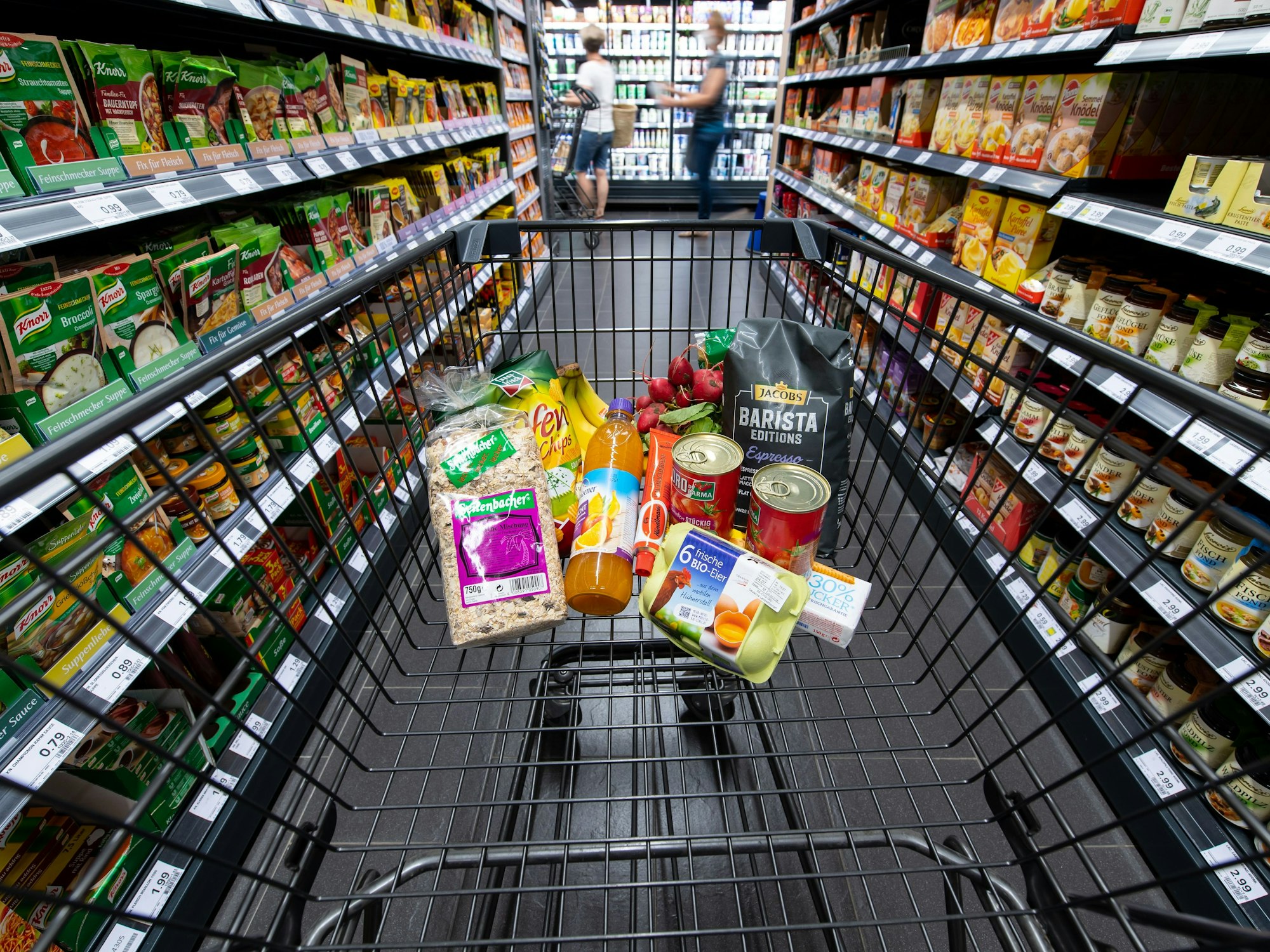 Verschiedene Lebensmittel liegen in einem Edeka-Supermarkt in einem Einkaufswagen.