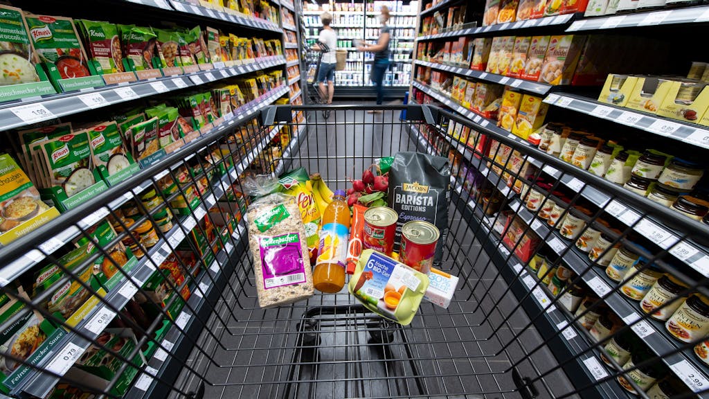 Verschiedene Lebensmittel liegen in einem Edeka-Supermarkt in einem Einkaufswagen.