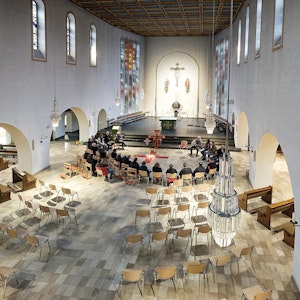 In der Kirche St Martin in Rheinbach wurden die alten Bänke weggeräumt. Eine Gruppe sitzt zur Andacht im Kreis beisammen.