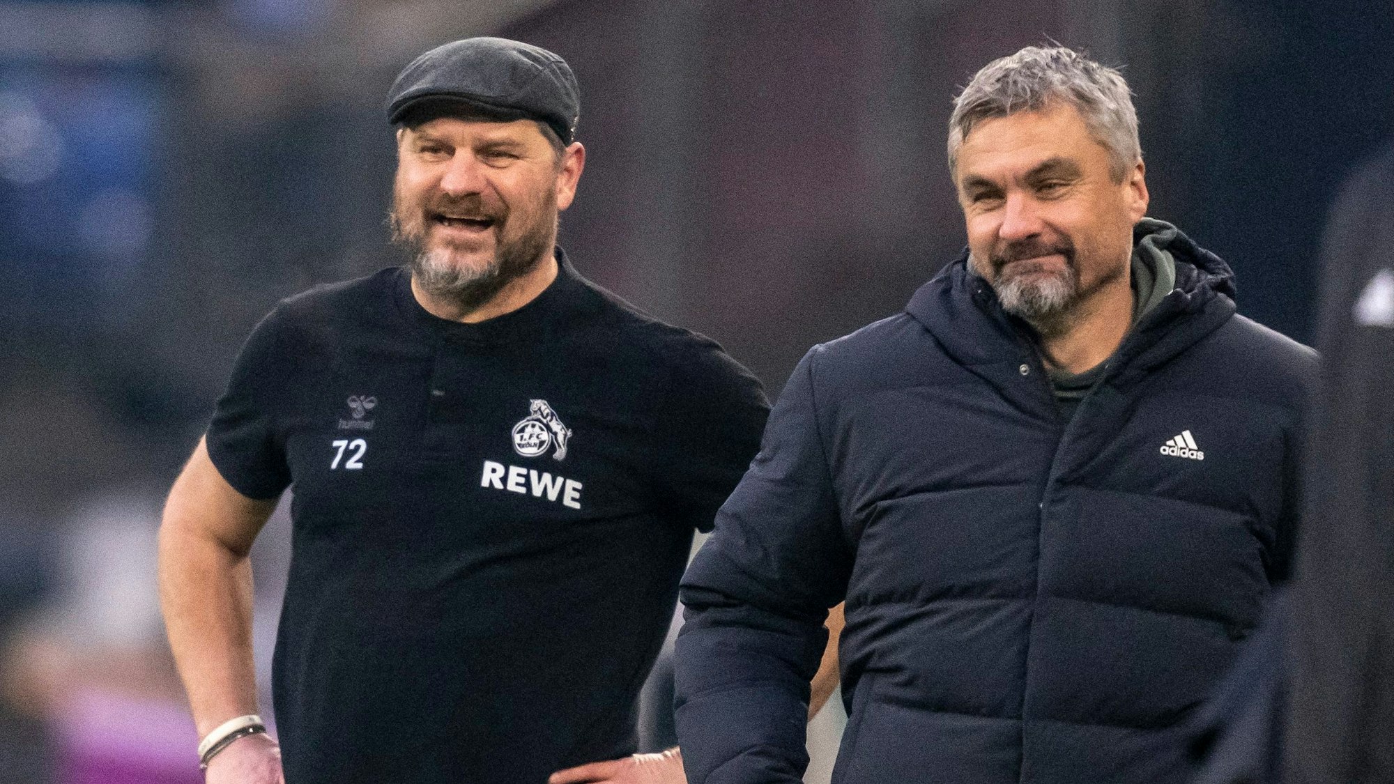 Kölns Trainer Steffen Baumgart (l) und Schalkes Trainer Thomas Reis scherzen miteinander.