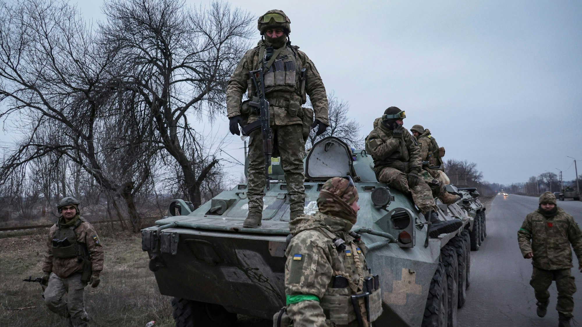 28.01.2023, Ukraine, Donezk: Ukrainische Soldaten stehen oben auf einem APC, bevor sie an die Frontlinie in der Region Donezk, Ukraine, fahren.