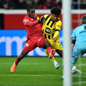 Dortmunds Karim Adeyemi (M) und Leverkusens Jeremie Frimpong kämpfen um den Ball.