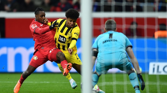 Dortmunds Karim Adeyemi (M) und Leverkusens Jeremie Frimpong kämpfen um den Ball.
