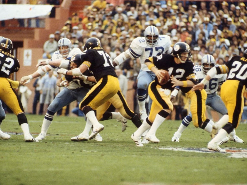 Steelers Quarterback Terry Bradshaw trägt den Ball aus der Pocket.