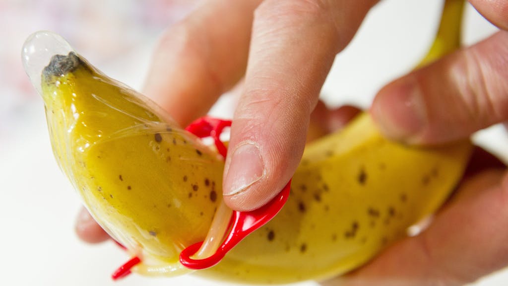 Das Foto aus dem Jahr 2014 zeigt eine Banane, über die ein Kondom gezogen wird.