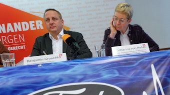 Benjamin Gruschka, Gesamtbetriebsratsvorsitzender der Ford Werke (l) und Katharina von Hebel, stellv. Gesamtbetriebsratsvorsitzende und Vorsitzende des europäischen Betriebsrates (r), sitzen bei einem Pressgespräch mit dem Ford-Betriebsrat zur Zukunft des Kölner Ford-Werks auf dem Podium.