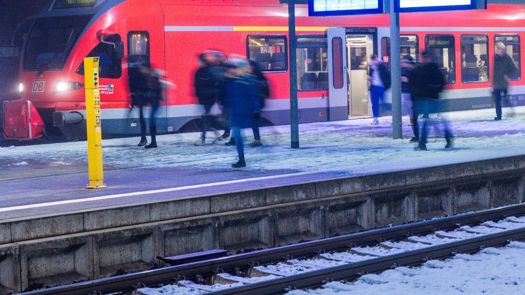 Fahrgäste steigen an einem Bahnhof aus einem Regionalzug.