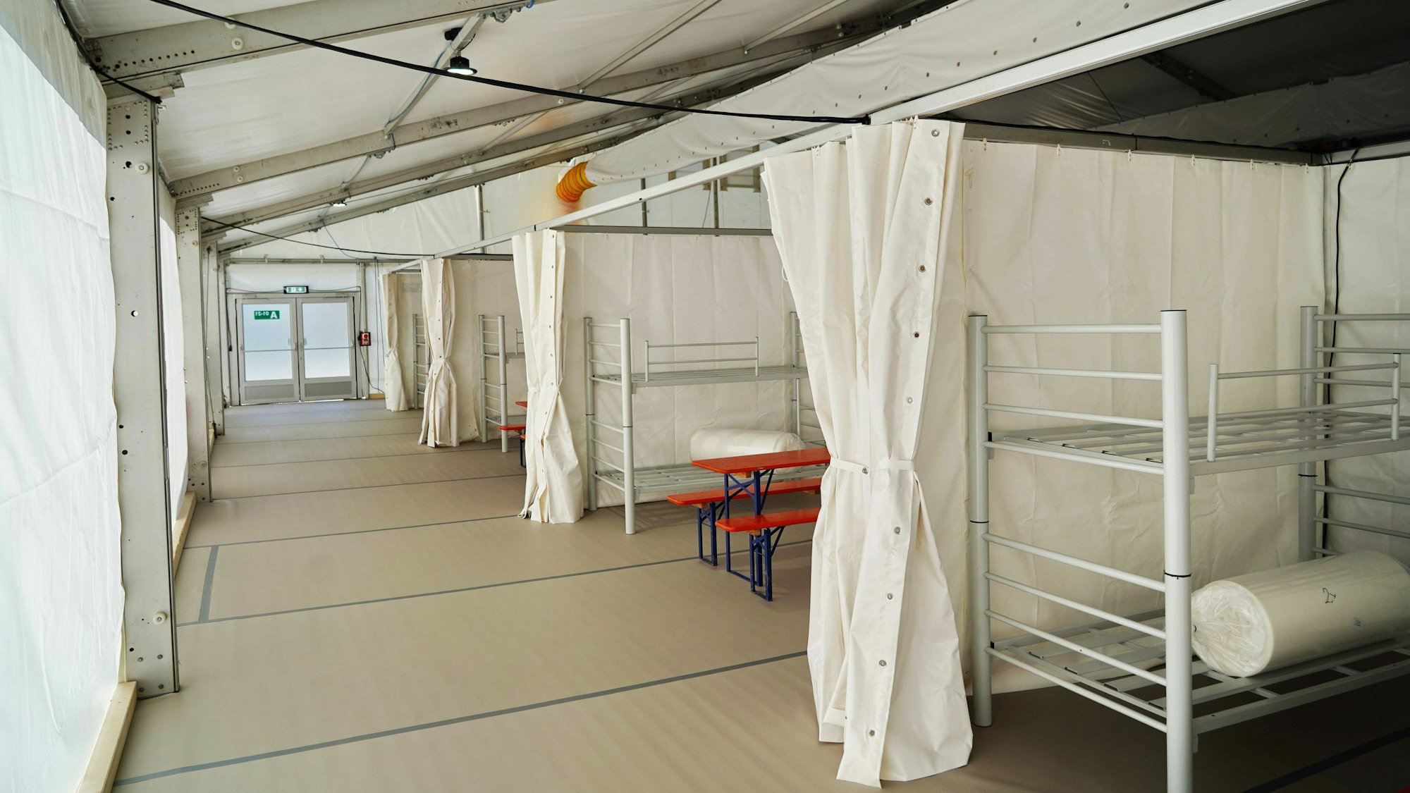 Blick in eine Notunterkunft für Geflüchtete mit Etagenbetten am Kölner Südstadion