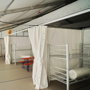 Blick in eine Notunterkunft für Geflüchtete mit Etagenbetten am Kölner Südstadion