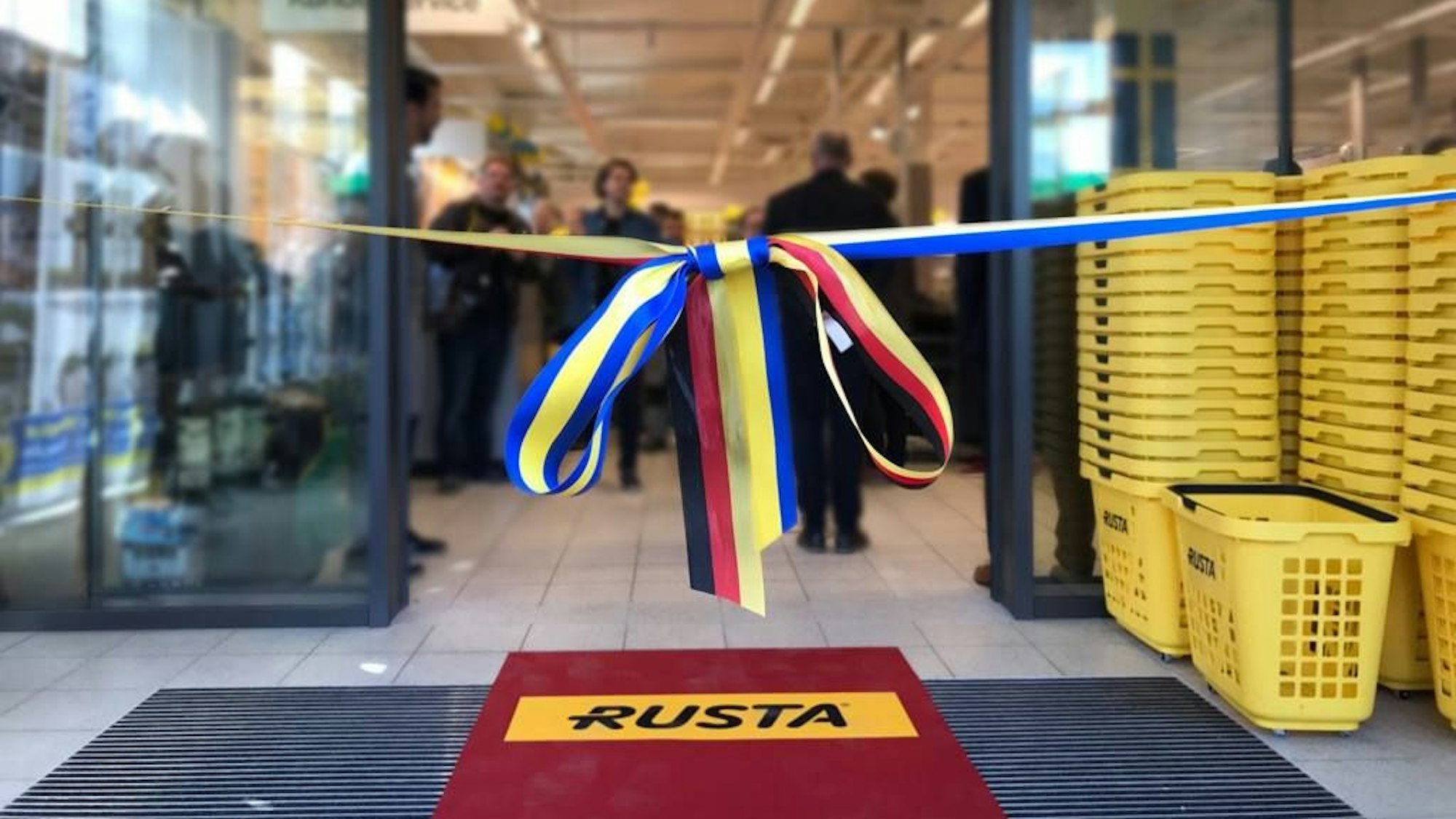 Zwei Bänder mit den Farben der schwedischen und der deutschen Fahne sperren einen Rusta-Markt ab. Bei der Eröffnung sind sie dann durchtrennt worden.
