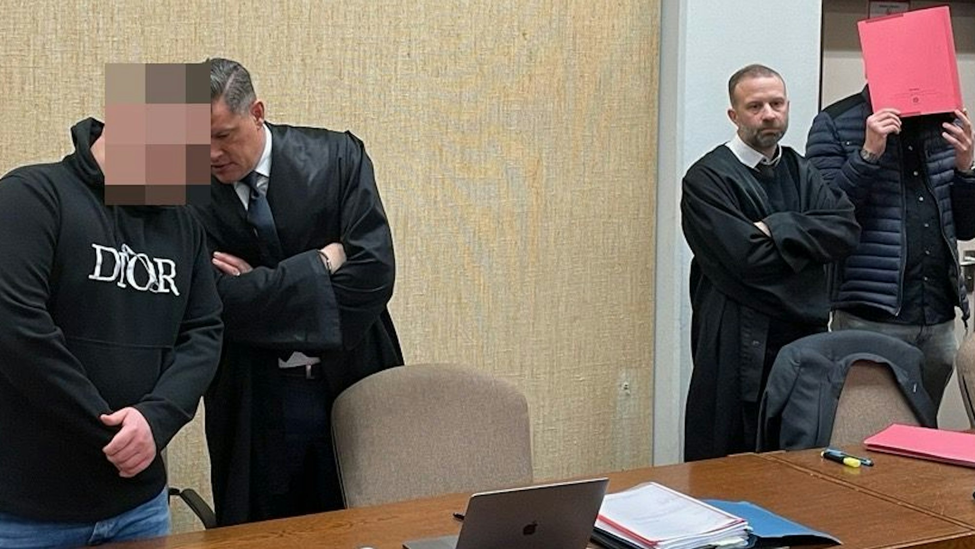 Die Angeklagten mit ihren Verteidigern Tobias Westkamp (r.) und Dietmar Bonn beim Prozess im Amtsgericht Köln.
